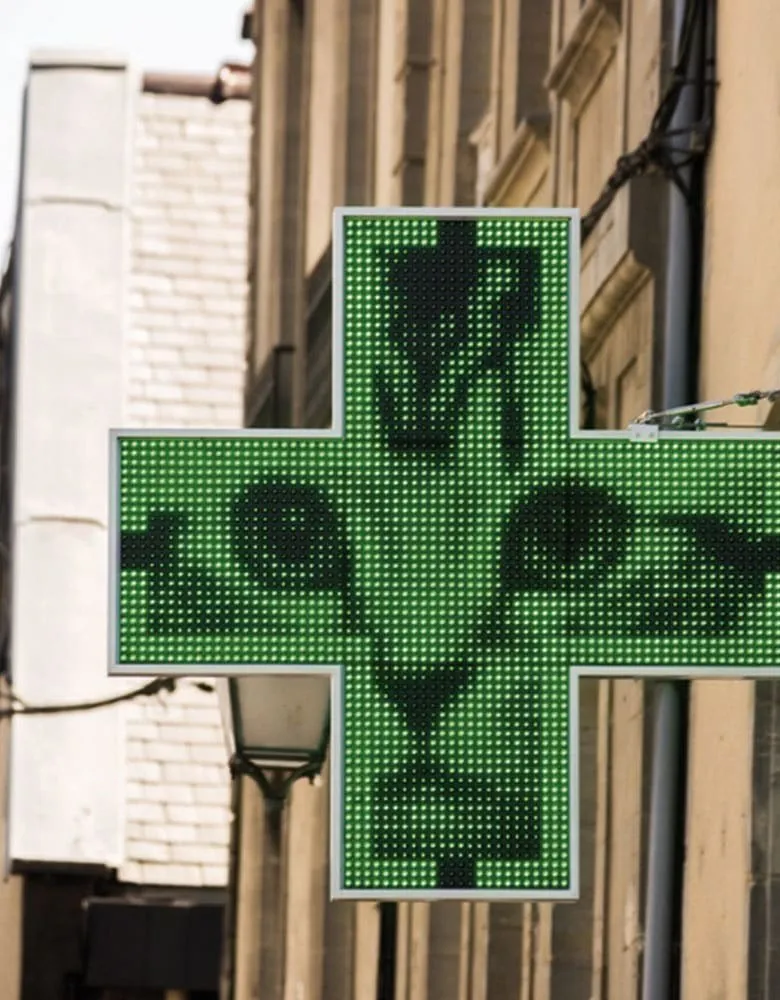 Croix de pharmacie à diodes verte sur une façade
