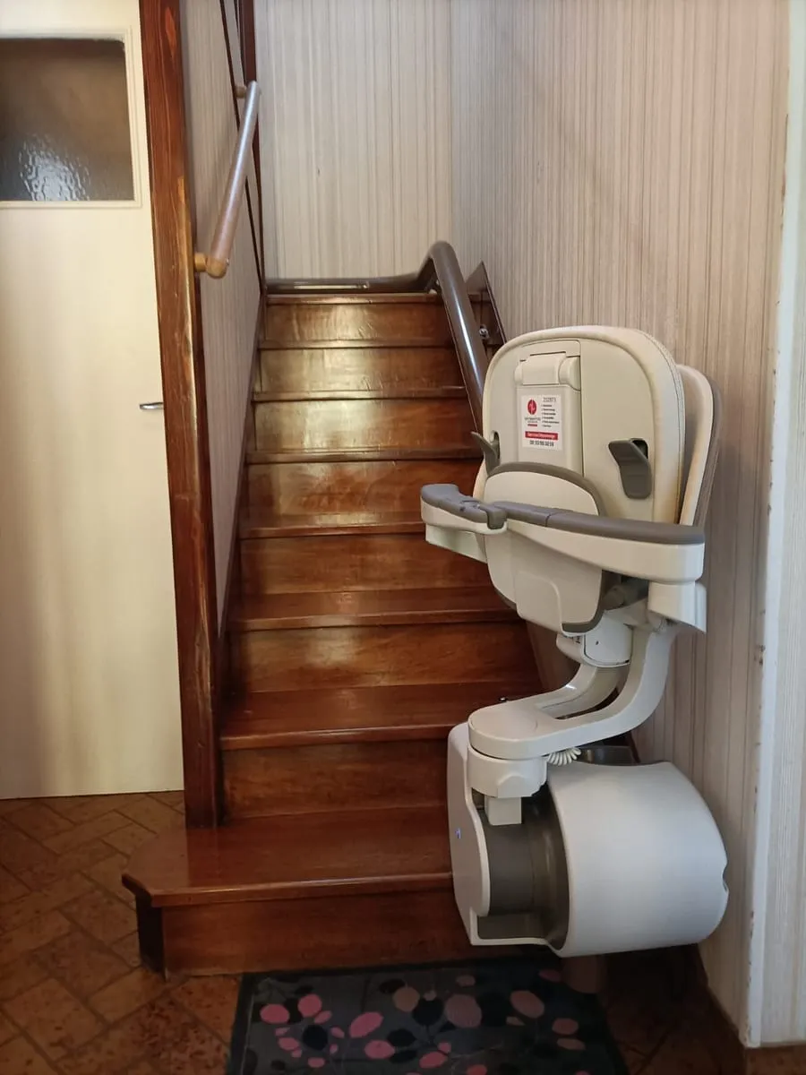 Monte-escalier installé au pied d’un escalier en bois dans une maison