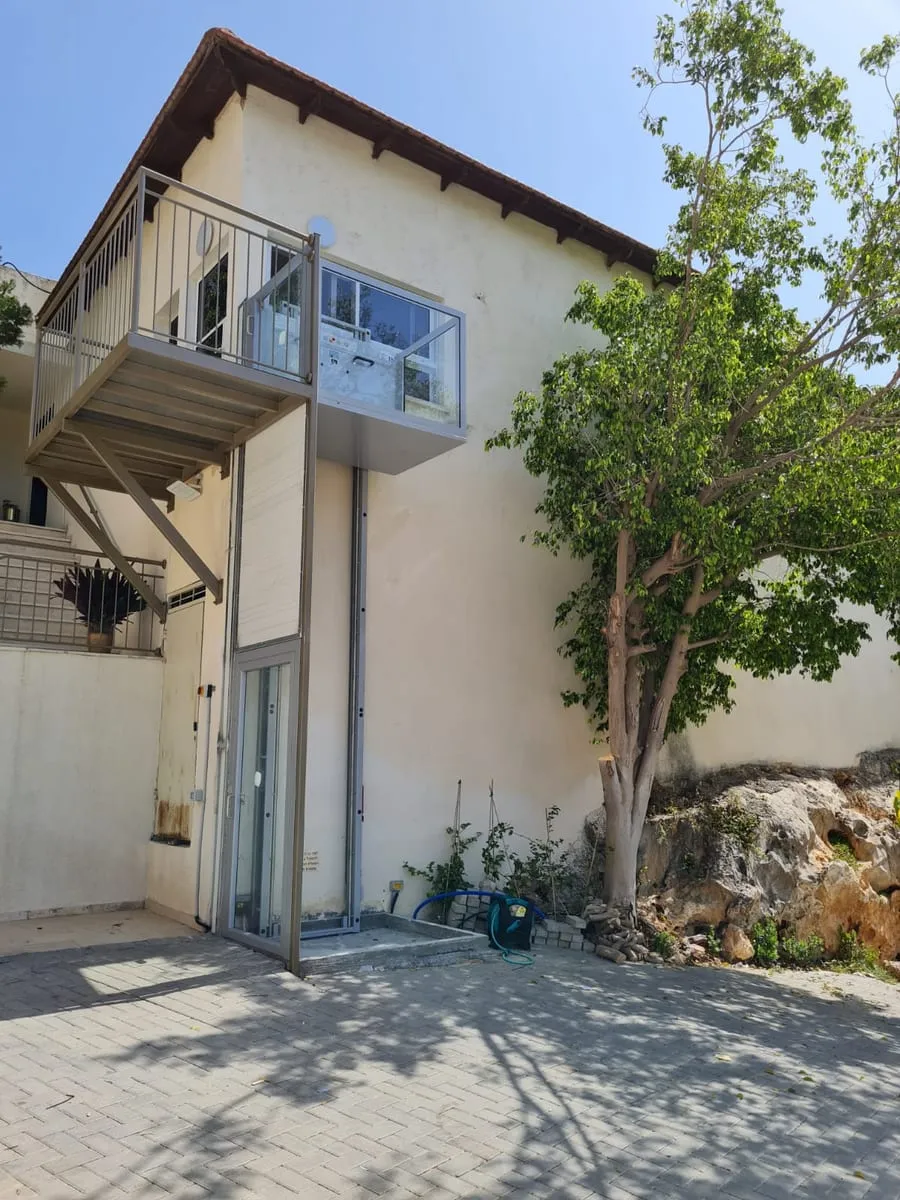 Élévateur vertical vitré installé à l’extérieur d’une maison