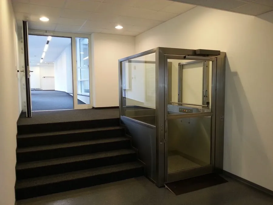 Plateforme élévatrice vitrée installée dans un hall d’immeuble